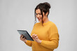 © Syda Productions - technology and people concept - happy woman using tablet computer over grey background