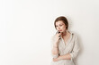 © Maxim - a victim of cruel domestic violence stands on a white isolated background holding a phone in his hands, thinking about a call, fingal under his eye