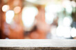 © qOppi - Empty wooden table space platform and blurred resturant or coffee shop background for product display montage.