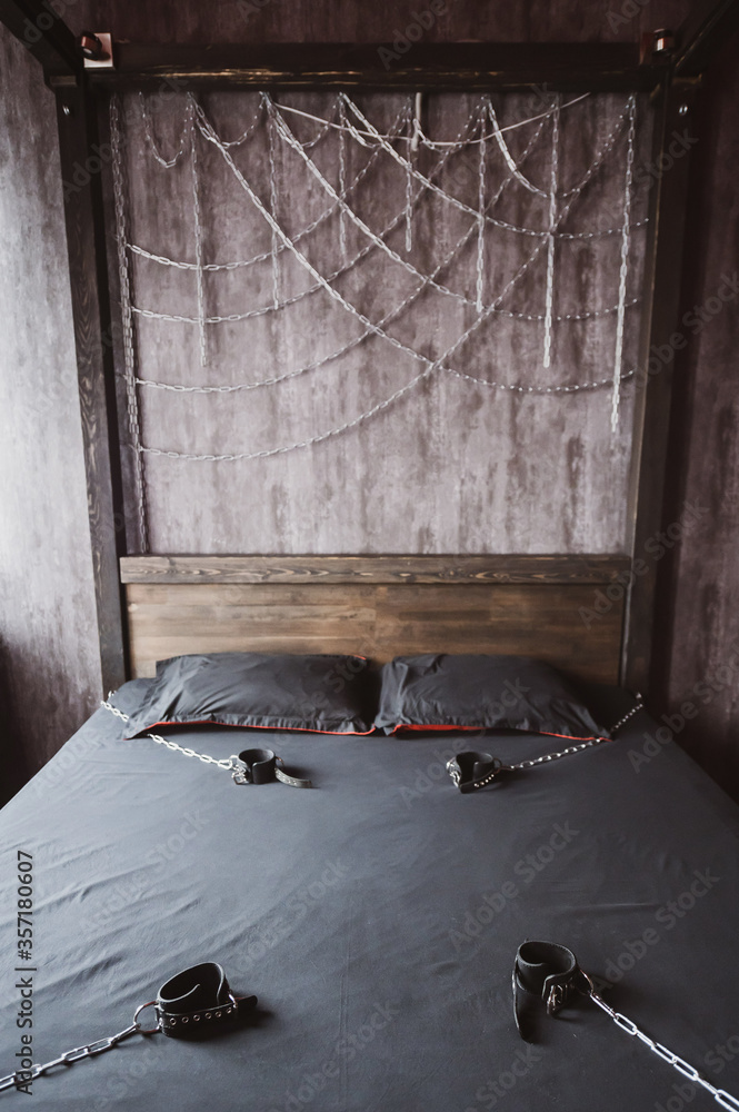 Bedroom for intimate meetings. VDSM equipment and sex toys. Leather  handcuffs with a chain on a gray sheet. Fifty shades of gray. Fetish  domination. Stock-bilde | Adobe Stock