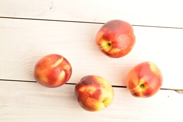 Ripe juicy organic nectarine, close-up, on a painted wooden table.