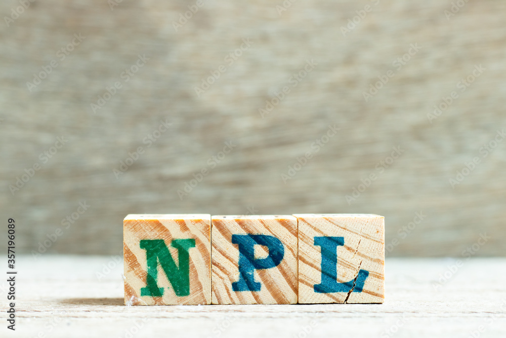Alphabet letter in word NPL (Abbbreviation of Non Performing Loan, Non-Patent Literature) on wood background