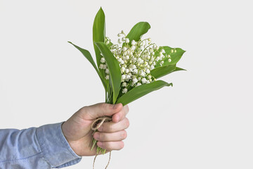 man holding lily of valley flower bouquet 