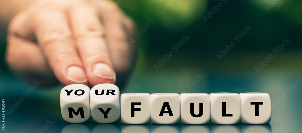 Hand turns dice and changes the expression "my fault" to "your fault". - obrazy, fototapety, plakaty 