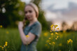 © Roman Osinski - Young woman hand moving over grass field with yellow flowers with sun soft light. Touching nature plants, close up passing hand. Concept of feeling free and happy, optimistic. Woman in the field.