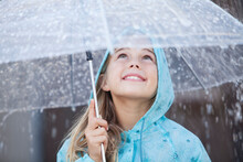Close Up Of Smiling Girl Under Umbrella In Downpour