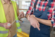 © zinkevych - Close-up of building worker hands applying bandage on his coworker forearm