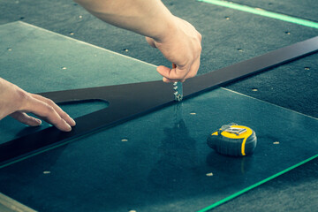 The glazier cuts the glass on a professional table in a glass factory