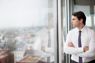 Wall Mural - Businessman looking out office window