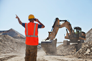 Wall Mural - Worker directing digger in quarry