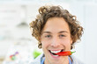 © Tom Merton/KOTO - Smiling man holding chili pepper in mouth