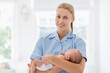 © Tom Merton/KOTO - Nurse holding newborn baby in hospital