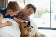 © Tom Merton/KOTO - Father and son petting dog on sofa