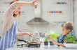 © Tom Merton/KOTO - Mother and son cooking in kitchen