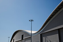 Curved Roof Of Warehouse And Blue Sky