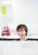 © Robert Daly/KOTO - Businesswoman wearing headset in office