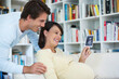 © Robert Daly/KOTO - Pregnant woman showing boyfriend sonogram