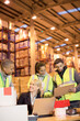 © Paul Bradbury/KOTO - Businesswoman and workers talking in warehouse