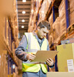 © Paul Bradbury/KOTO - Worker reading clipboard in warehouse