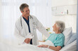 © Chris Ryan/KOTO - Doctor talking to elderly patient in hospital