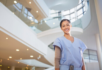 Portrait of smiling nurse in hospital atrium