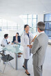 © Chris Ryan/KOTO - Doctor and businessman shaking hands in meeting
