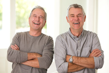 Portrait of senior men laughing with arms crossed