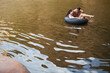 © Sam Edwards/KOTO - Couple playing in inner tube in lake