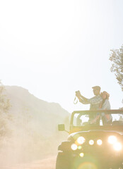 Wall Mural - Couple with digital camera in sport utility vehicle