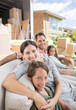 © Paul Bradbury/KOTO - Family sitting on sofa near moving van in driveway