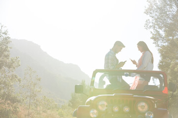 Wall Mural - Couple using cell phones in sport utility vehicle