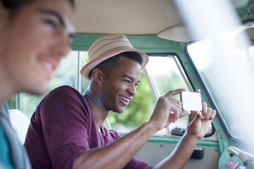 Wall Mural - Man using camera phone in camper van