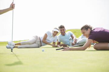 Wall Mural - Friends laying on golf course