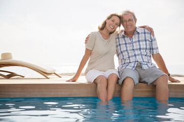 Poster - Senior couple dipping feet in swimming pool