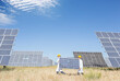 © Martin Barraud/KOTO - Scientists carrying solar panel in rural landscape
