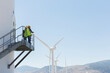 © Martin Barraud/KOTO - Workers standing on wind turbine in rural landscape