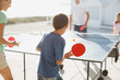 © Paul Bradbury/KOTO - Family playing table tennis together outdoors