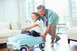 © Paul Bradbury/KOTO - Father pushing son in toy car