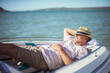 © Paul Bradbury/KOTO - Older man relaxing in boat on water
