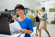 © Dan Dalton/KOTO - Businesswoman talking on headset at table in office building