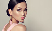 Asian Model  Fashion Girl  With Tassel Earrings And  Pink Dress.  Oriental Girl Model, Cosmetics, Cosmetology And Fashion.
