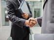 © Dan Dalton/KOTO - Businessmen shaking hands outdoors