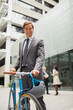 © Dan Dalton/KOTO - Businessman walking bicycle outside of office building