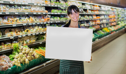 Wall Mural - Clerk holding blank card in produce section of grocery store