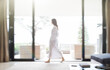 © Astronaut Images/KOTO - Woman in bathrobe walking through living room