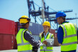 © Paul Bradbury/KOTO - Business people and worker talking near cargo containers