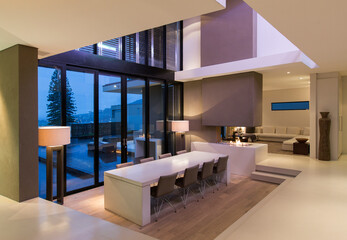 View of modern dining room with large table and chairs at night