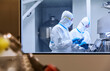 Scientists in clean suits using digital tablets in laboratory