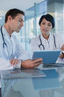 © Dan Dalton/KOTO - Doctors discussing patient's treatment at desk, using digital tablet