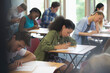 View of students sitting at desks during test in classroom 